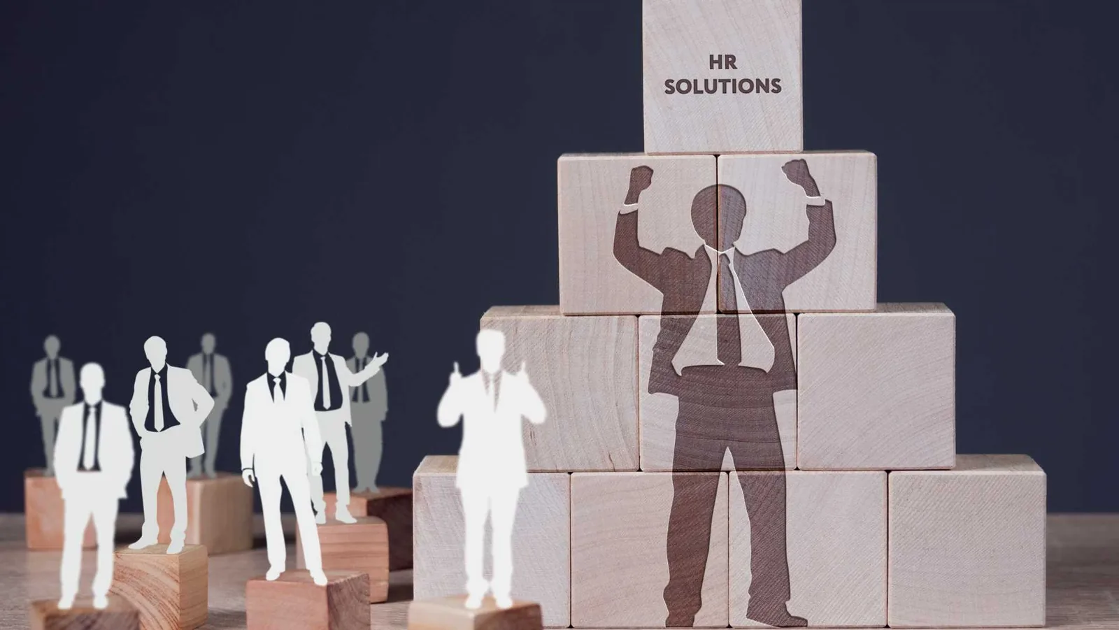 Wooden blocks forming a pyramid with silhouettes of business professionals and the text "HR Solutions" on top, symbolizing teamwork and success — concept for the Best HR Software for Karachi Businesses.