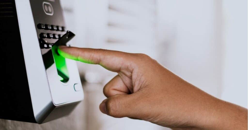 Close-up of a person using a fingerprint scanner for attendance verification — concept of Biometric Attendance Integration in HCM Pakistan to enhance employee tracking and workplace automation.