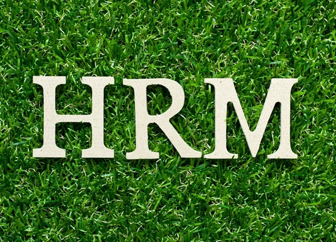 The word HRM on green grass symbolizing Eco-Friendly HR Software Pakistan and sustainable human resource management practices.