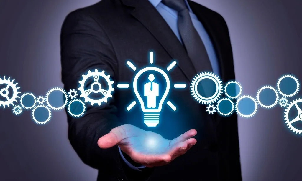 Business professional presenting HR innovations with interconnected gears and a glowing light bulb symbolizing digital HR solutions.